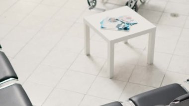 Sağlık hizmetleri resepsiyon masası kayıt formları ve randevu raporlarıyla bekleme odasında. Klinik lobisindeki boş tezgah iyileşme ve hastalıkları tedavi etmek için kullanılıyor. El kamerasıyla..