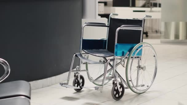 病院のロビーエリアに配置された車椅子 診断センターでの医療予約に使用される病院の受付カウンター 障害者に優しい臨床施設 フロントデスクでの回復 — ストック動画