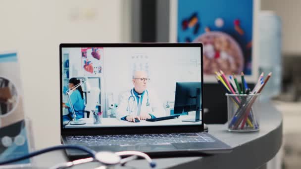 Medyk Korzystający Wideokonferencji Online Recepcji Laptop Umieszczony Ladzie Rejestracyjnej Szpitala — Wideo stockowe