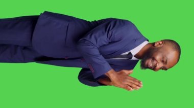 Dikey video: Dini erkek modelin yeşil perde arkaplanının üzerinde dua eden elleri göstermesi, tanrıya dua etmesi ve iyi şanslar dilemesi. İyimser iş adamı ruhani ve inançlı