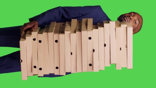 垂直视频 美国黑人经理背着一大堆披萨盒 在绿色屏幕背景下提供外卖快餐餐的镜头 穿正式服装的年轻人送餐 — 图库视频影像