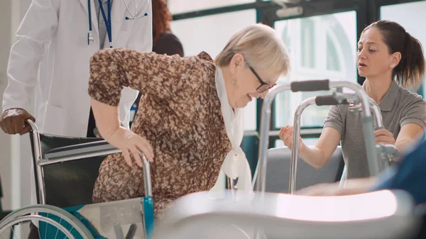휠체어를 나이든 여성은 보건소에서 프레임을 사용하여 치료를 건강하다고 느낍니다 의사가 — 스톡 사진