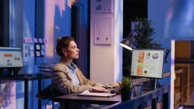 Gece hologramla çalışan bir kadın girişimci, holografik görüntüyü ekonomik grafikleri bulmak için hareket ettiriyor. Finansal iş raporu oluşturmak için diyagramları analiz eden profesyonel danışman.