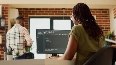 Çevrimiçi uygulama geliştirmek için kod kullanan kadın programcı, veritabanı yazılımını programlamak için terminal penceresinde html betiği ile çalışıyor. BT yöneticisi yapay zeka ağı planlıyor. El kamerasıyla..