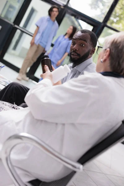 Starszy Lekarz Specjalista Omawiający Leczenie Pacjentem Pokazując Butelkę Tabletek Podczas — Zdjęcie stockowe