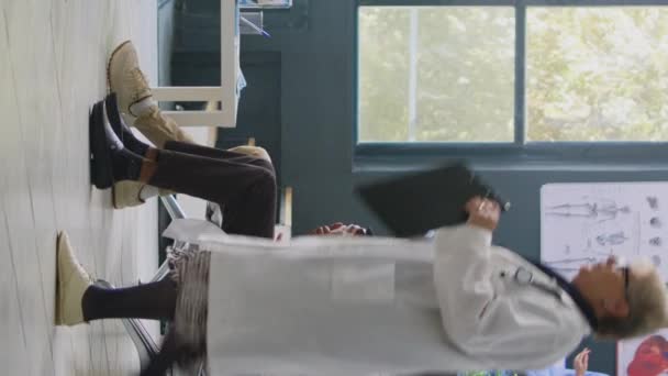 Pionowe Wideo Lekarz Trzymający Butelkę Witamin Poczekalni Szpitalnej Wyjaśniając Leczenie — Wideo stockowe