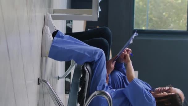 Vertikální Video Doktor Pomáhá Starému Muži Lékařskou Formou Nemocniční Čekárně — Stock video
