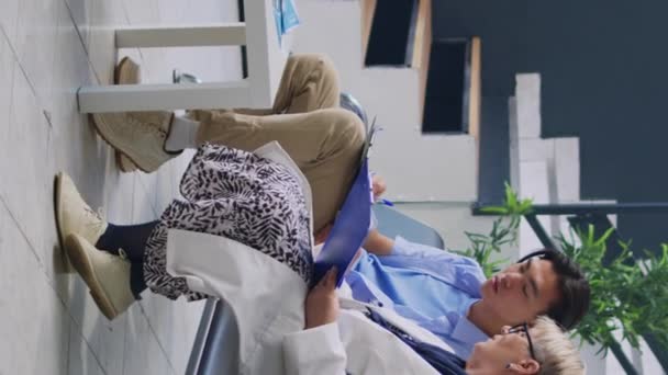 Verticale Video Ouderen Medisch Rapport Vullen Met Aziatische Patiënt Tijdens — Stockvideo