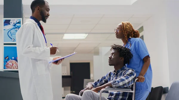 Arzt Berät Rollstuhlfahrer Mit Körperlicher Behinderung Besprechung Wartezimmer Des Krankenhauses — Stockfoto