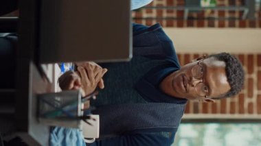 Dikey video: Ofis çalışanları şirket kârını artırmak için çözümler hakkında konuşarak iş projesi planlıyorlar. Yıllık raporlar ve verilerle araştırma sunumu oluşturmaya çalışan modern ortaklar