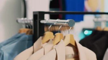 Askı ve askılarla dolu boş bir perakende mağazası, alışveriş merkezinde asılı gündelik giysiler. Giysileri indirimde olan modaya uygun bir butik, küçük ticari faaliyet konsepti..