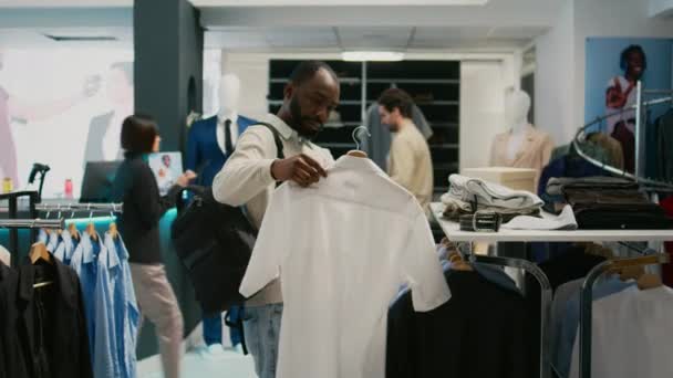 Detaljhandelskund Undersöker Nya Skjortor Samling För Att Köpa Formella Kläder — Stockvideo