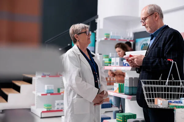 Starszy Klient Pytający Farmaceutę Pigułki Kardiologiczne Podczas Robienia Zakupów Aptece — Zdjęcie stockowe