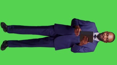 Dikey video: Dijital tablet üzerinde iş toplantısına katılan şirket yöneticisinin görüntüsü, çevrimiçi video konferans sohbetinde konuşmak için aygıt kullanıyor. Girişimci uzaktan konuşuyor