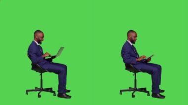 Bilgisayarla ve tabletle çalışan genç girişimci kameraya iş elbisesi giyip internet sitesinde bilgi arıyor. Dijital aygıt ve taşınabilir pc kullanan başlangıç yöneticisi.