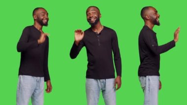 Dostça el sallayan mutlu bir adam ya da izole edilmiş yeşil ekran arka planında poz veren insanlara veda eden. İyimser bir insan, kendine güvenen bir erkek modele merhaba deyip selam veriyor..