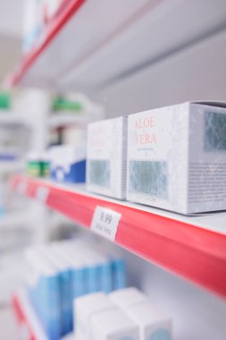 Aloe Vera yüz kremi eczane raflarında duruyor. Muayene sırasında müşterilerin gelip almasını bekliyor. Eczane ilaç ürünleri ve vitaminlerle dolu. Sağlık hizmeti kavramı
