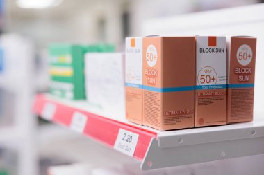 Müşterilere reçeteli ilaç veya tedavi satmak için spf ürünleri ve ilaç kutularıyla dolu eczane raflarının seçici odak noktası. Vitamin ve ilaçlarla dolu boş eczane