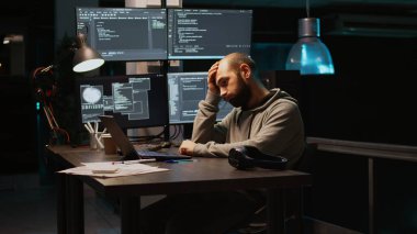 Genç adam yorgun hissediyor ve programlama kodu üzerinde çalışıyor, veritabanı bilgilerini ve dizüstü bilgisayarda html senaryosunu yazıyor. Yetişkin ofiste uyuyakalıyor, terminal penceresini kullanmaktan yoruluyor. El kamerasıyla..