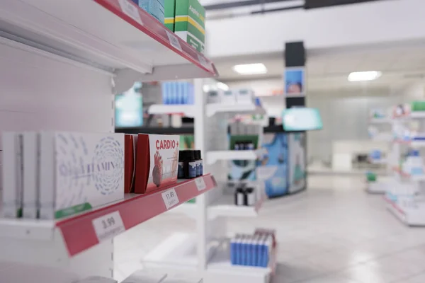 Empty pharmacy store equipped with shelves full with pharmaceutical products and supplements ready for clients. Drugstore with nobody in it filled with vitamins, pills packages and drugs bottles