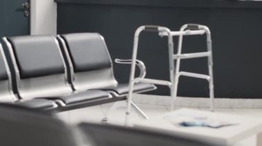 Hastane resepsiyonunda yürüyüş çerçevesi, resepsiyonda tıbbi kayıt formları. İyileşme hizmetleri için yürüyüş yardımı olan boş bekleme odası, randevular için sağlık sigortası.