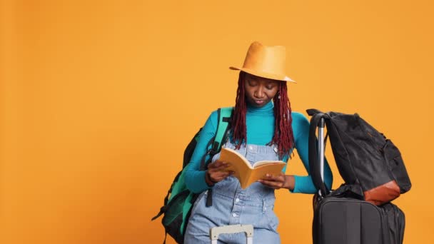女性游客在旅行时阅读书籍 在城中带着行李和行李箱玩乐 年轻人兴奋地喜欢故事或文学小说 度假目的地 — 图库视频影像