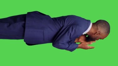 Dikey video: Modern çalışanın stüdyoya hava öpücüğü göndermesi ve romantik jestler yapması, kamerada iyimser ve pozitif hissetmesi. Genç yetişkin yeşil perde arkaplanı üzerinde öpüşüyor.