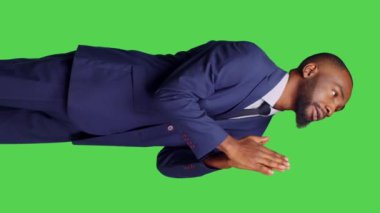 Dikey video: Takım elbiseli bir ofis çalışanının Tanrı 'dan talih dileyip dileğini yerine getirmek için dua etmesi ve iyi şanslar dilemesi. Erkek şirket çalışanı dua ederken el ele tutuşuyor, dindar ve...