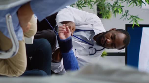 Pionowe Wideo Afrykański Amerykański Lekarz Konsultingowy Pacjenta Pomiar Nadciśnienia Tętniczego — Wideo stockowe