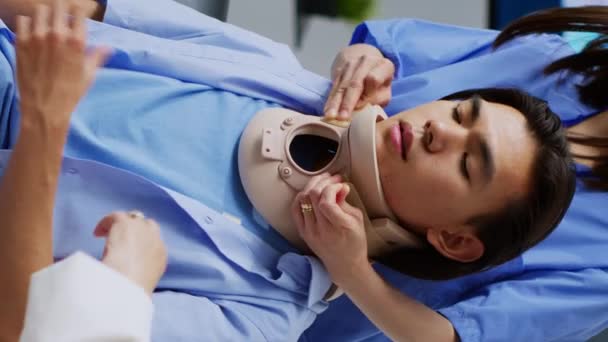 Vídeo Vertical Traumatologista Ajudando Paciente Asiático Tomar Colar Cervical Sala — Vídeo de Stock