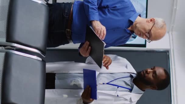Vídeo Vertical Médico Explicando Diagnóstico Enfermedad Paciente Mayor Durante Examen — Vídeos de Stock