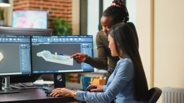 Female engineers analyzing clamp component prototype, working with industrial 3d software. Team of mechanical developers creating engine product for machinery production, creative asset.