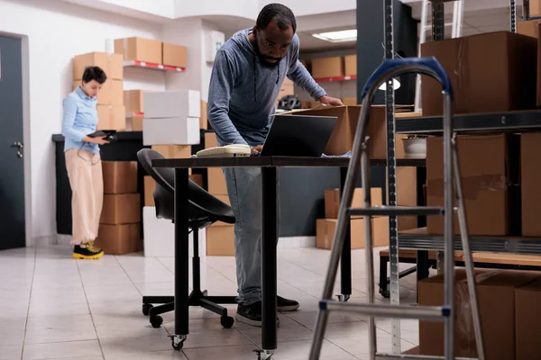 Depo Çalışanı Müşteri Paketlerini Hazırlamadan Önce Dizüstü Bilgisayardaki Ulaşım Lojistiğini — Stok fotoğraf