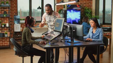 Masada birden fazla monitör kullanarak sanatsal gelişim endüstrisiyle çalışan yaratıcı içerik yaratıcıları. Yapım departmanı çalışanları yapay zeka teknolojisi geliştiriyor..