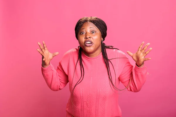 非洲裔美国人模特儿在粉红背景的工作室里摆姿势时感到沮丧和好斗 精神崩溃 反应不愉快的紧张女人 — 图库照片