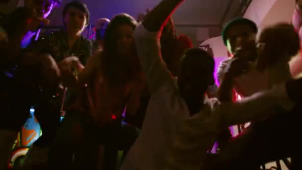 パーティーで踊る若者たちのハメ撮り ディステークでファンキーなダンスの動きをカメラに映し出す ナイトクラブでクラブ音楽を楽しんでいる男性と女性のグループ 手持ち撮影 — ストック動画