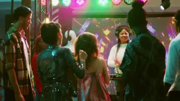 ステージ上でDjパネルを使用し クラブパーティー オーディオクラブ機器でライブ電子音楽を作成し 現代の女性 ダンスフロアの人々のための音楽を混合ヘッドセットとファンキーな女の子 — ストック動画