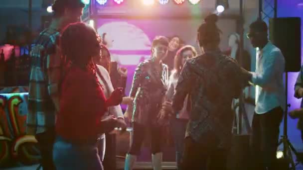 ダンスパーティーでは ダンスフロアで現代的なロボットの動きを示す電子音楽で楽しんでいる男性と女性 社交集会やクラブイベントで踊っている陽気な友達 手持ち撮影 — ストック動画