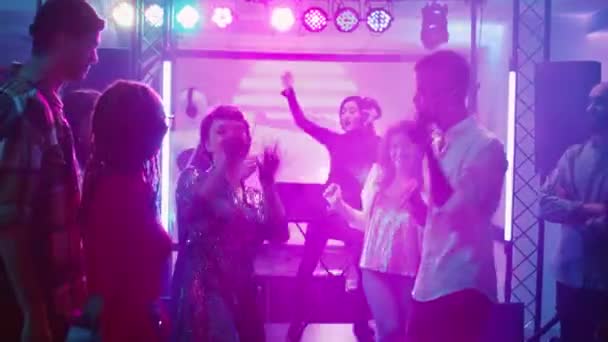 不同的人在夜总会里玩着时髦的音乐 展示着现代机器人在舞池里跳舞的动作 参加社交活动 庆祝活动的年轻人 手持射击 — 图库视频影像
