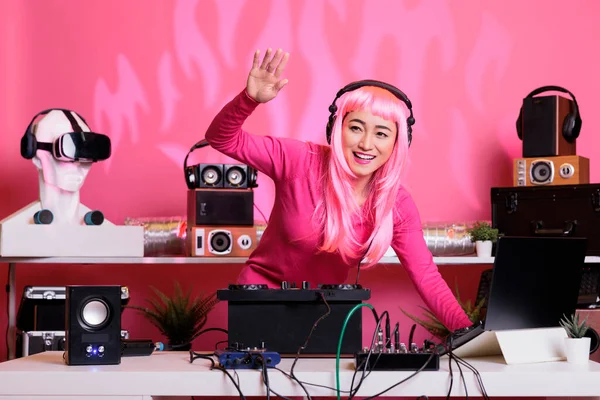 ピンクの髪とブラウスを持つアーティストは 夜にクラブのDjテーブルに立って ミキサーコンソールを使用してテクノと電子音楽を混合しながら 楽しみを持っています 演奏を楽しむ演奏家 — ストック写真