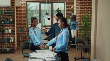 Mutlu meslektaşlar başarıyı kutluyor, iş karını elde ettikten sonra el ele tutuşuyor ve tezahürat yapıyorlar. Mutlu ofis çalışanları gelişim sonuçlarından ve başarılı takım çalışmalarından memnun..