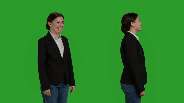 スタジオで正式なスーツを着て カメラに緑色の画面上にポーズをとっている会社の労働者の閉鎖 社員として働く女性モデル 自信を持って行動する背景に立つ — ストック写真
