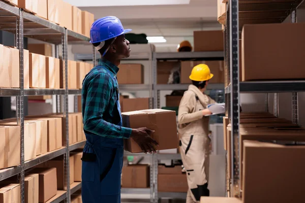 工厂运输部门的员工站在纸板箱 管理物流和销售 持有待运客户订单的非裔美国人仓库工人 — 图库照片
