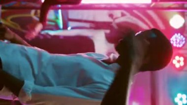 Dikey video: Çeşitli insanlar dans pistinde zıplıyor, gece kulübünde break dans savaşıyla eğleniyorlar. Neşeli erkekler ve kadınlar elektronik DJ müziğiyle dans partisinden zevk alıyorlar. El kamerasıyla..