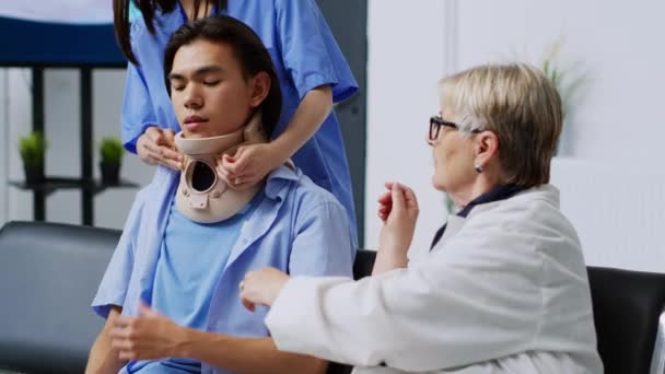 전문의 동양의 환자가 대기실에서 자궁경부 목걸이를 꺼내는 치료에 설명한다 위생병들은 — 비디오