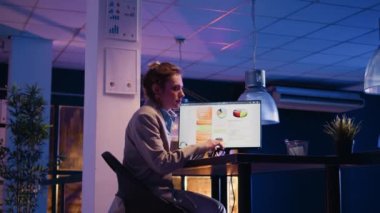 Genç çalışan esniyor ve masa başında uykulu hissediyor. Ofisteki mali iş raporları üzerinde çalışıyor. Yorgun, yeni başlayanlar için yatırım projesi planlayan, geceleri uykulu hisseden. Üçayak atışı.