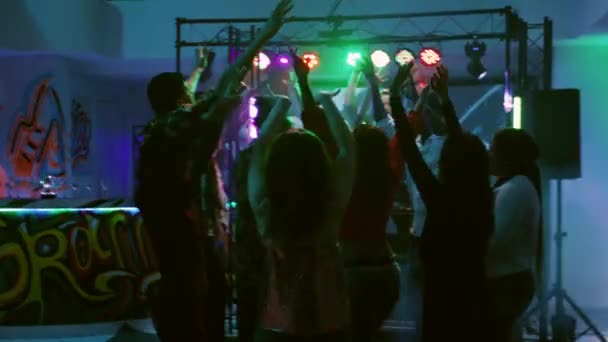 快乐的朋友们在时髦的音乐上跳舞 与Dj一起在舞台上和聚光灯下聚会 一群多样化的人在舞池里跳着舞 在俱乐部的活动中玩得很开心 手持射击 — 图库视频影像