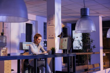 Yönetici yöneticisi finansal büyüme raporunu analiz ediyor, şirketin kar raporunu bilgisayarda yazıyor. İş kadını, pazarlama istatistiklerinde gece geç saatlere kadar çalışıyor.