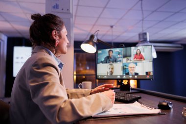 İş kadını, çevrimiçi video görüşmesi sırasında uzak meslektaşlarına finansal stratejiyi anlatıyor. Yatırım planında şirket kârını artırmak için fazla mesai yapan genç girişimci