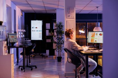 Şirket stratejisinde fazla mesai yapan iş kadını, başlangıç ofisindeki mali grafikleri analiz ediyor. Yatırım planını daktilo eden yönetici, pazarlama projesi için iş fikirleri üreten yönetici.